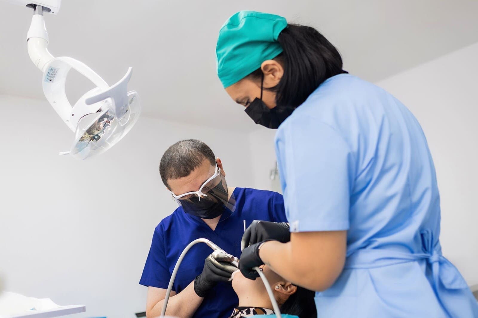 Medic stomatolog și asistentă efectuând tratament dentar la Sanodent