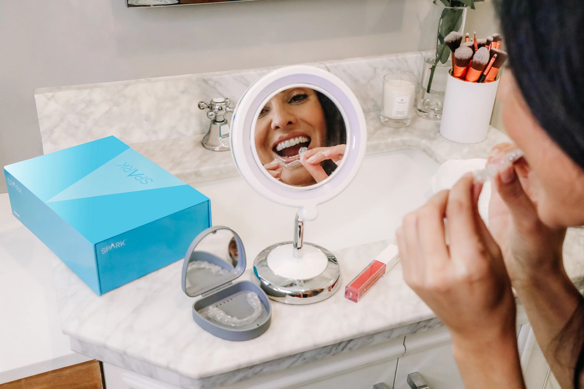 Detaliu al unei femei care se privește în oglindă, evidențiind alignerele Spark aproape invizibile